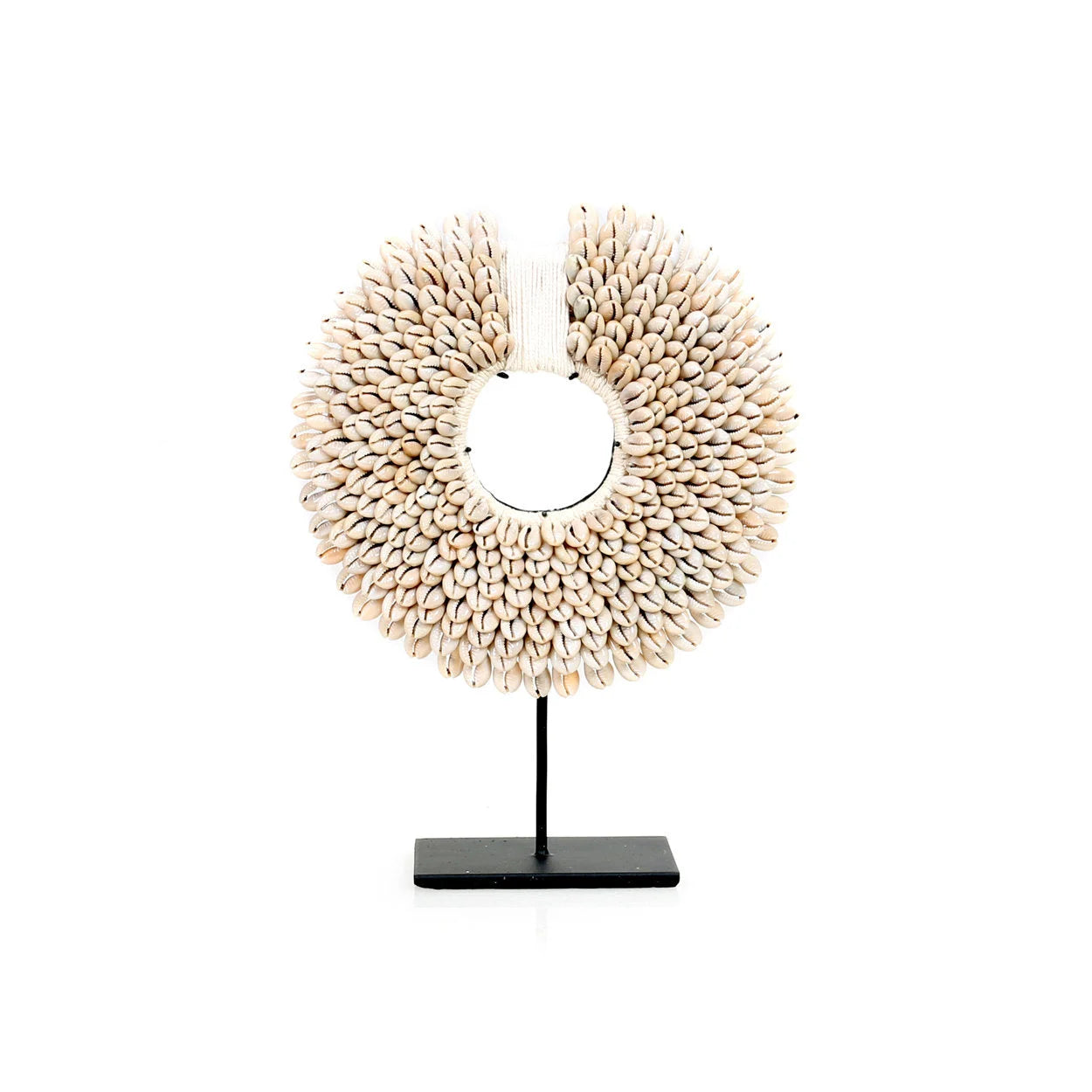 Un collier décoratif en cauris sur un support noir.