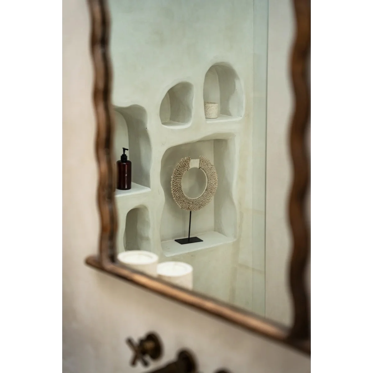 Niches murales blanches organiques avec distributeur de savon brun foncé et œuvre texturée