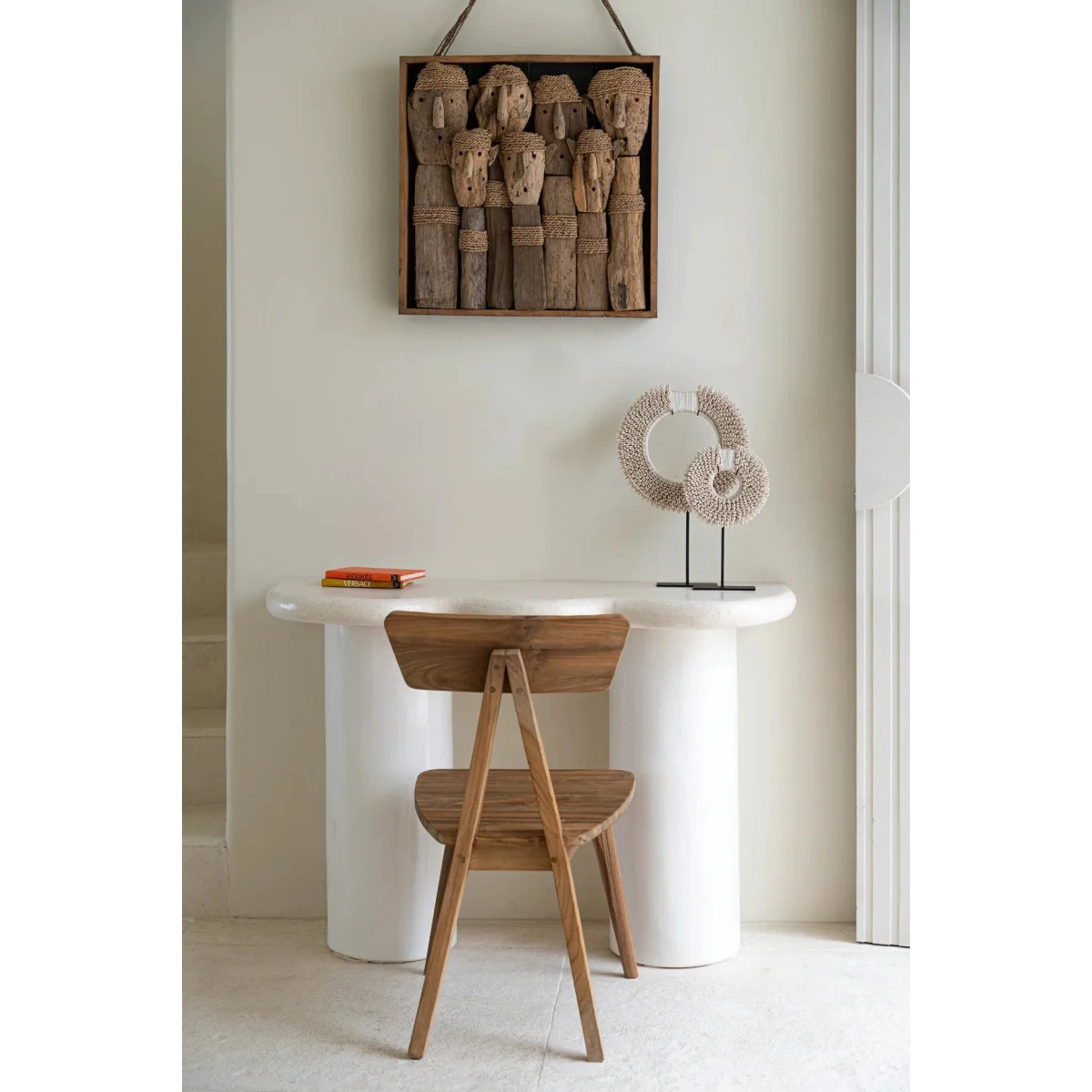 Œuvre murale en bois avec visages tribaux sculptés sur socle noir en métal