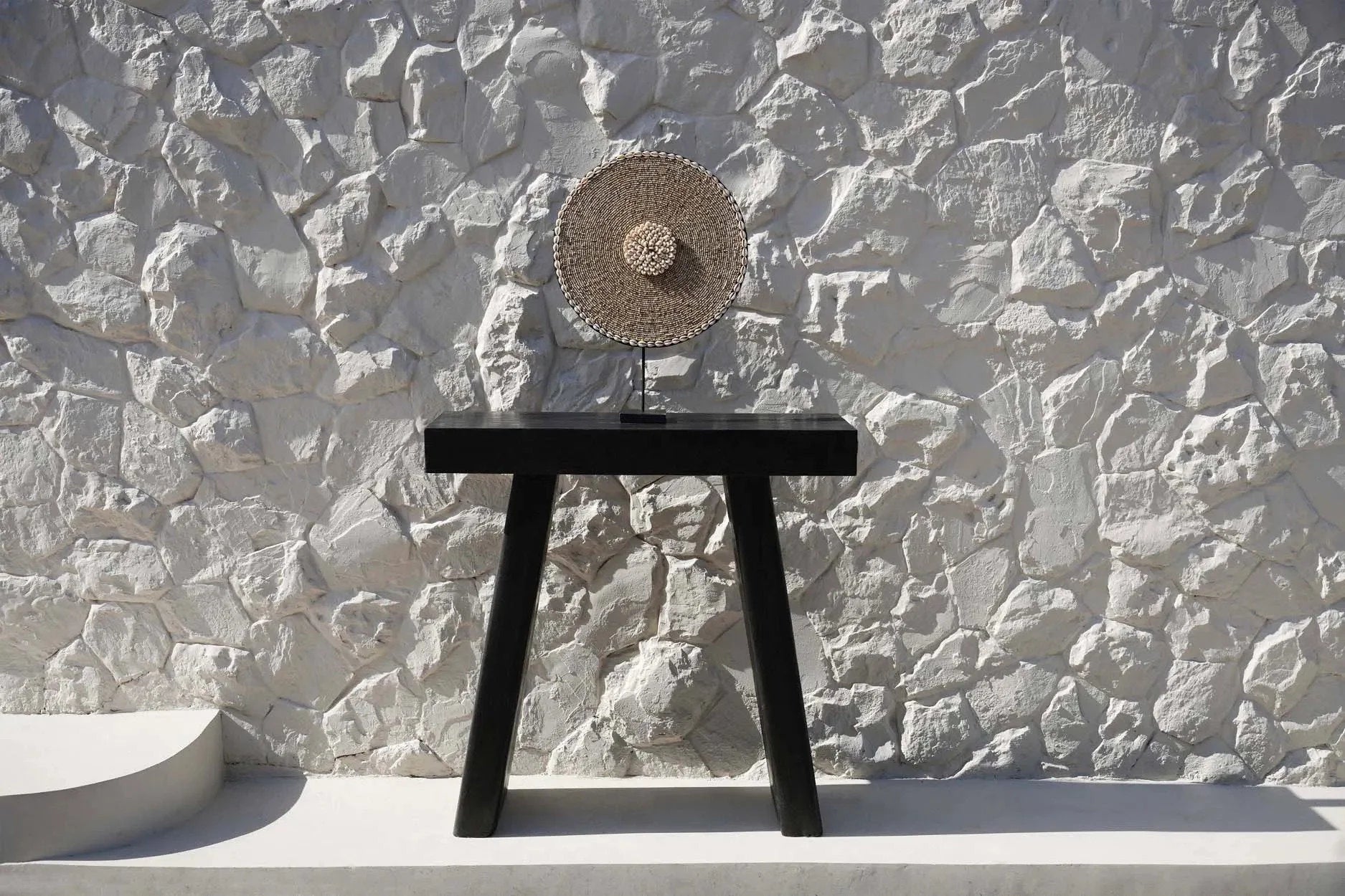 Disque décoratif en paille tressée avec nœud central sur socle noir