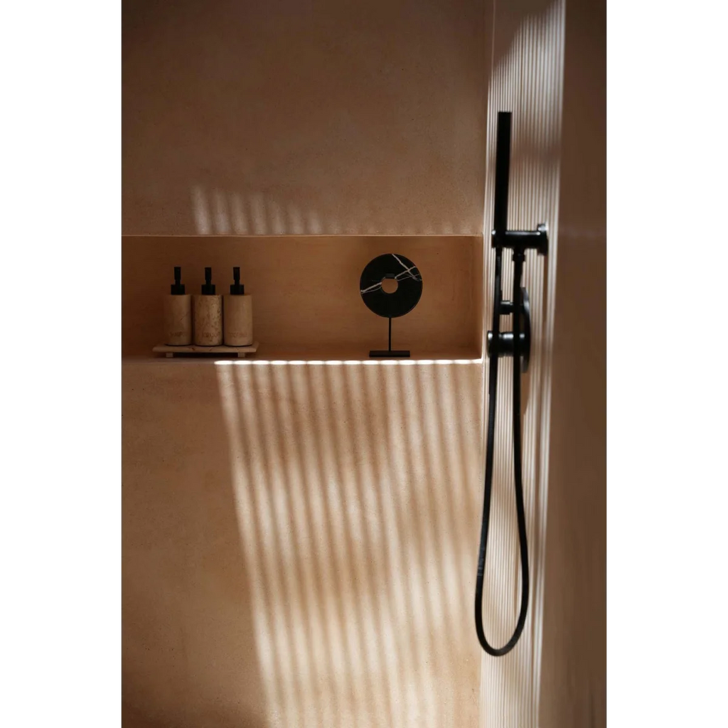Système de douche noir moderne avec tête de douche à main sur un socle en marbre noir