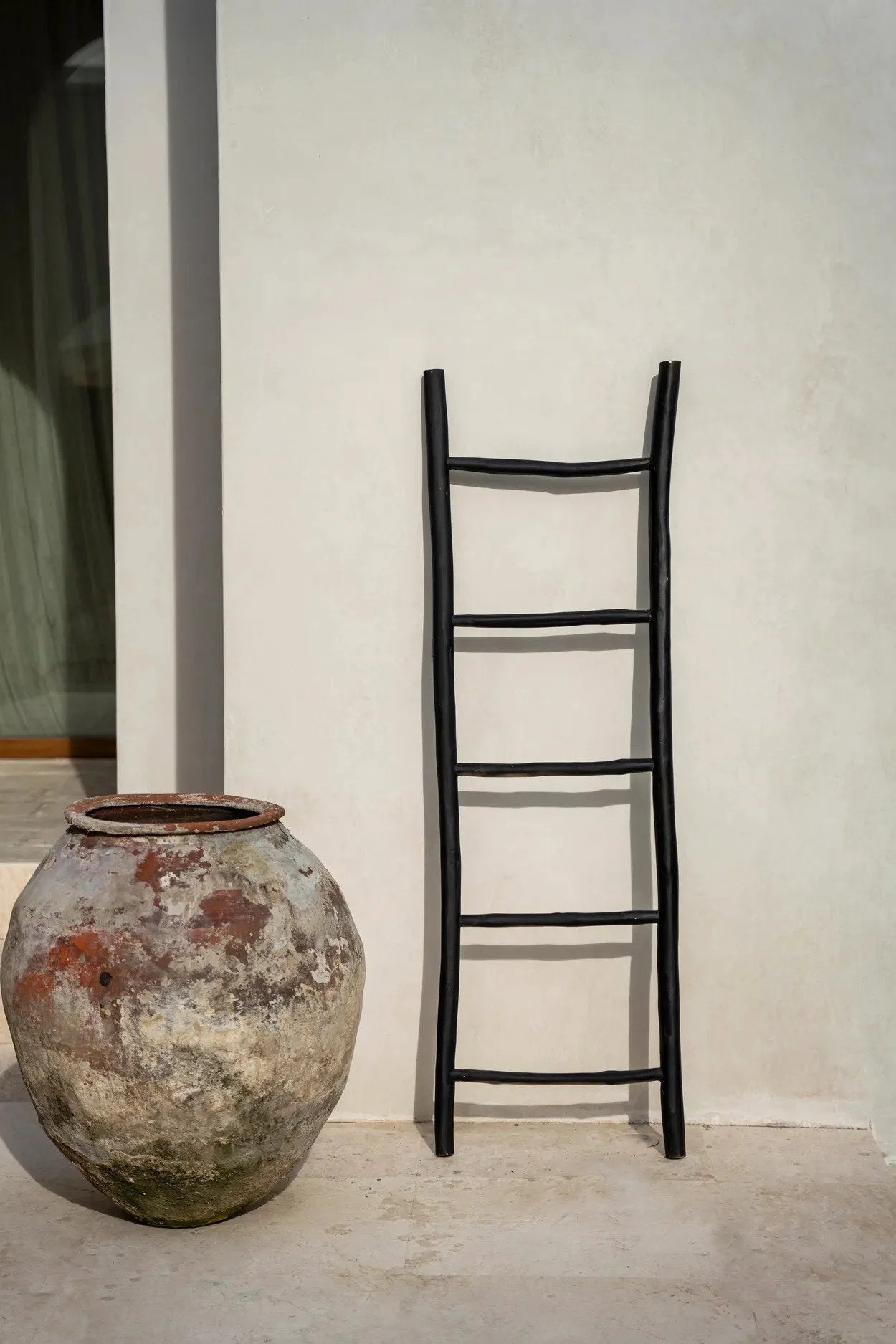 Pot en terre cuite usé avec une échelle décorative en teck noir de 165 cm