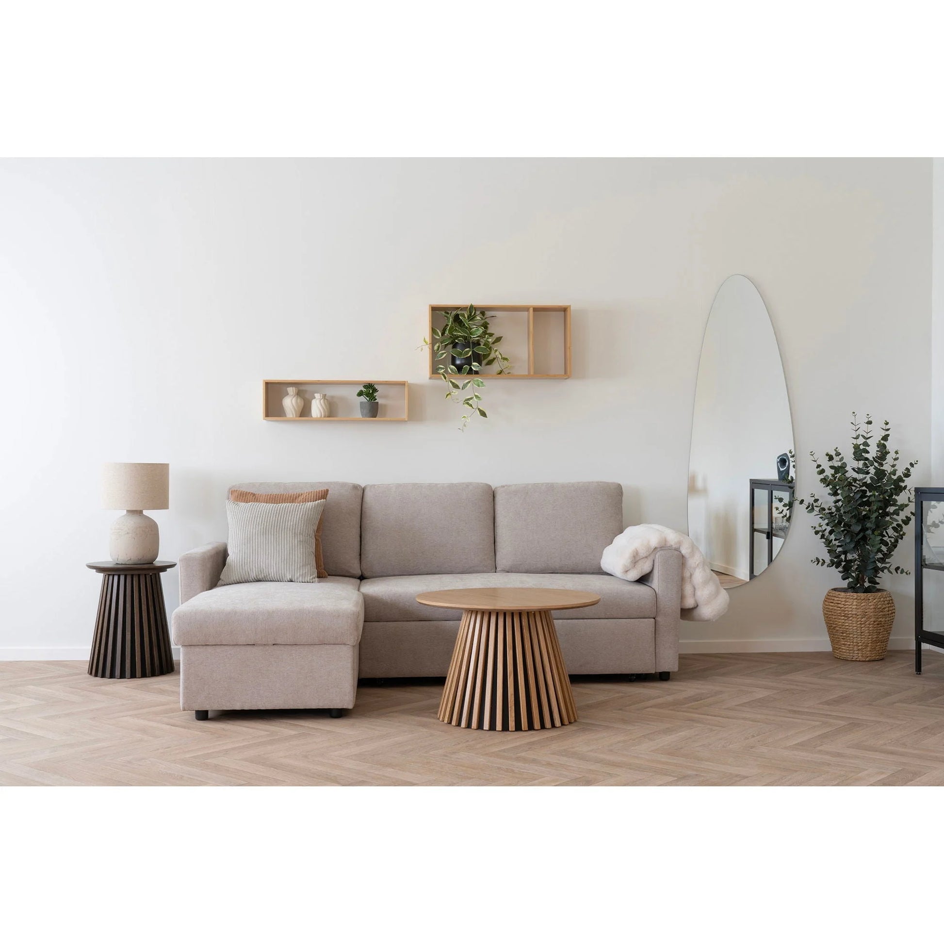 Canapé sectionnel beige en tissu dans la salle à manger élégante avec étagère murale en bambou naturel