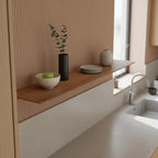 Vase cylindrique noir avec branches d’eucalyptus sur étagère murale en teck 90x16 cm