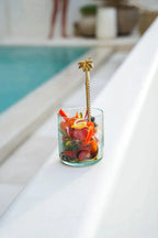 Gobelet en verre recyclé vert d’eau organique avec salade colorée et cuillère dorée en forme de palmier