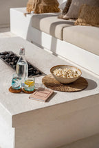 Bol en céramique beige rempli de popcorn sur set en paille tressée