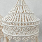 Gros plan des franges et des motifs complexes de l'abat-jour en macramé, tissé à la main pour une touche artisanale.