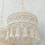 Deux abat-jours en macramé suspendus côte à côte, affichant un style bohème chic avec des franges longues et des motifs tressés.