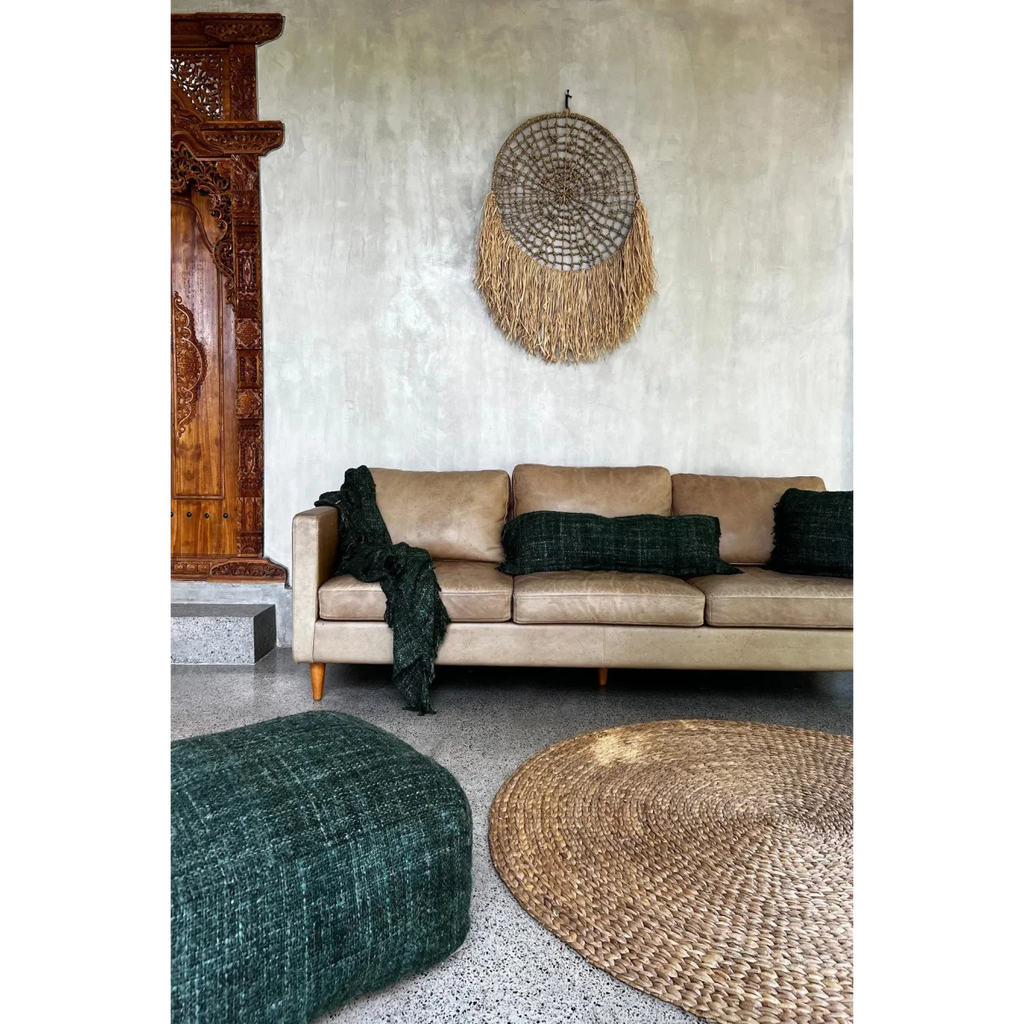 Canapé en cuir tan avec coussins verts foncés et couverture assortie pour décoration intérieure