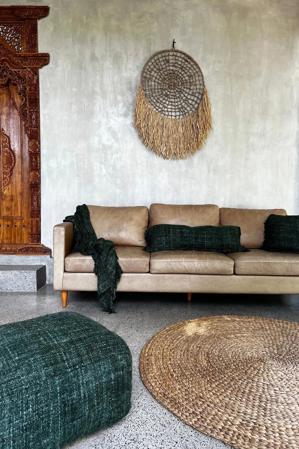 Canapé en cuir tan avec textiles vert foncé pour le produit Grand attrape-rêves mural