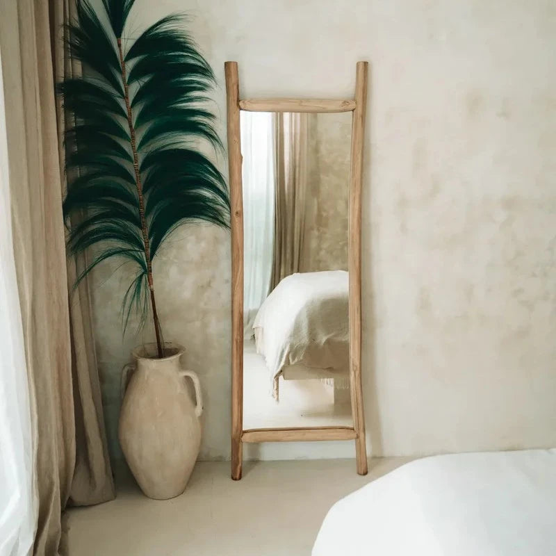 Miroir en teck dans une chambre avec un décor bohème et un lit en fond