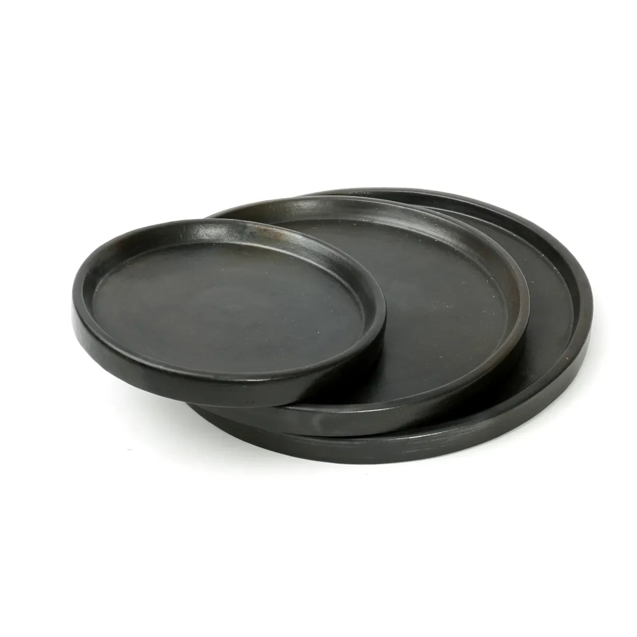 Pile de grands plateaux ronds en terre cuite noire brûlée de 30 cm