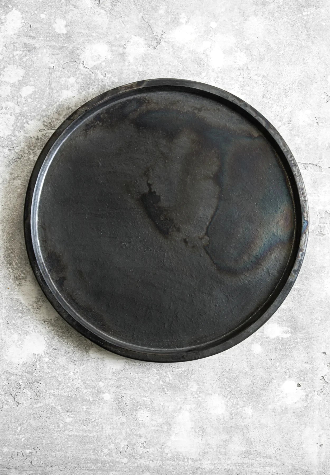 Plat en terre cuite noire brûlée de 30 cm avec une pizza ronde en fonte noire