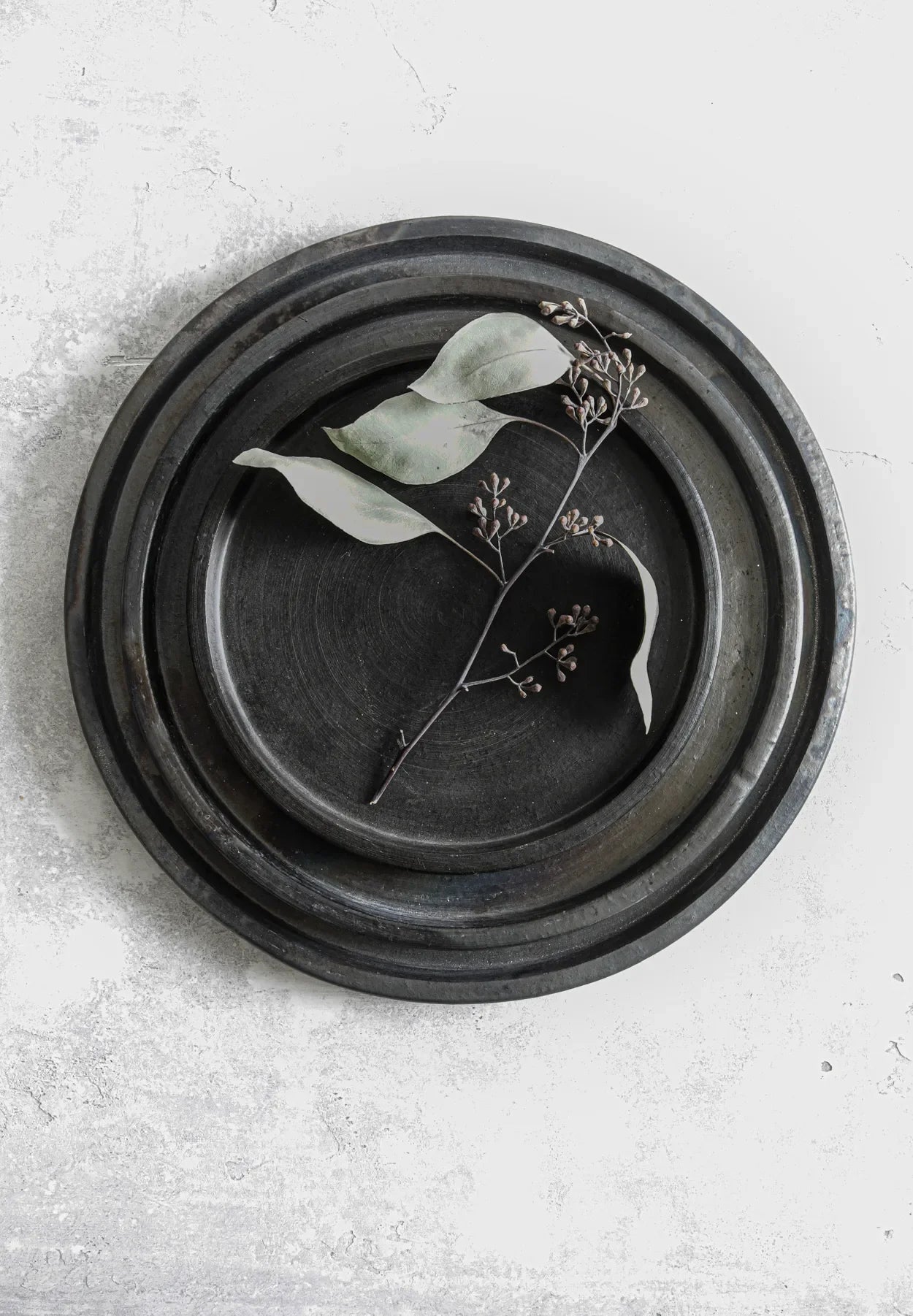 Grande assiette en terre cuite noire brûlée de 30 cm avec feuilles et brin décoratif