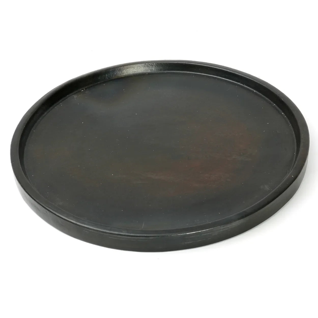 Plat rond en terre cuite noire brûlée sur un plateau en bois foncé de 30 cm