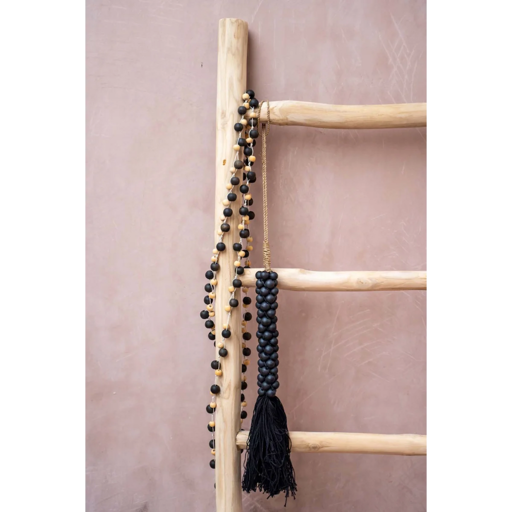Échelle en bois avec collier de perles noires et gland torsadé