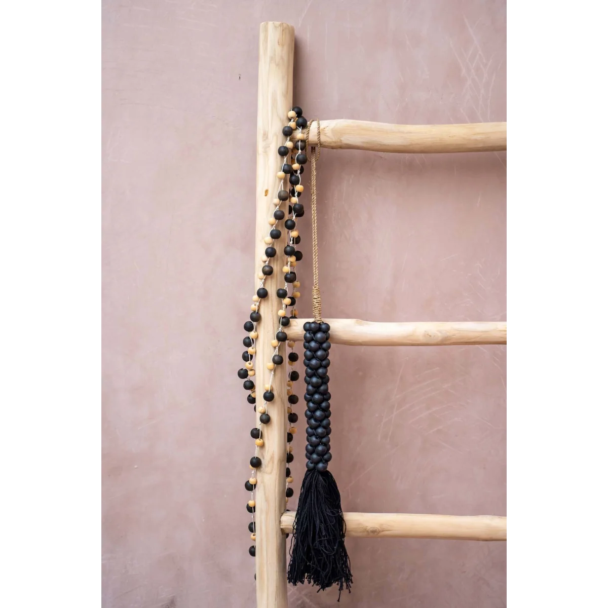 Échelle en bois avec collier de perles noires et gland torsadé