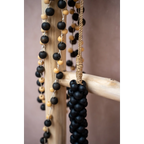 Guirlande murale en perles de bois noir mat et naturel avec accents bois et suspension corde dorée