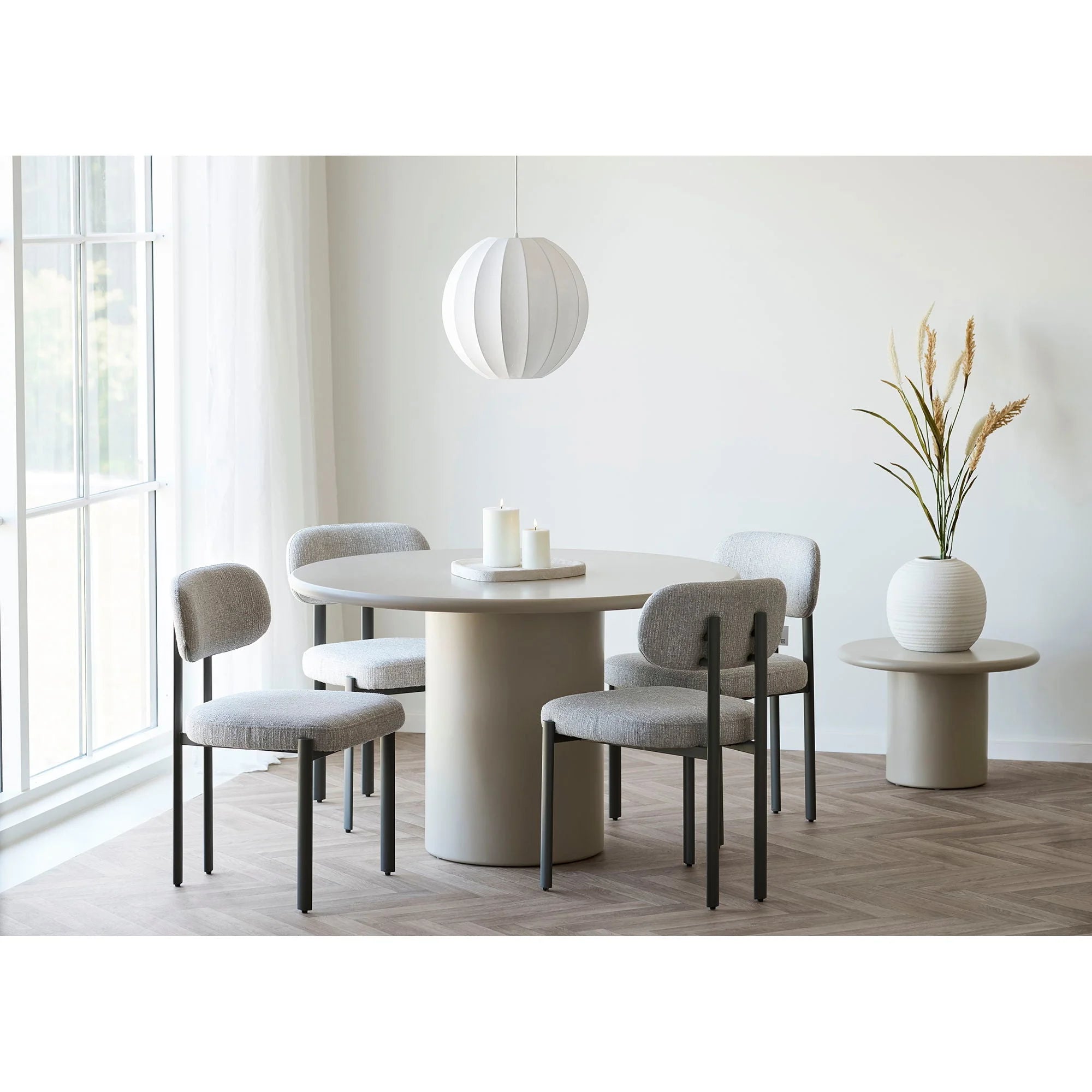 Table ronde moderne en béton mat beige avec chaises grises rembourrées