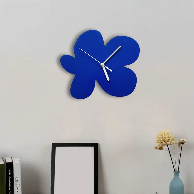 Horloge fleur abstraite bleue accrochée au mur, design moderne et artistique.