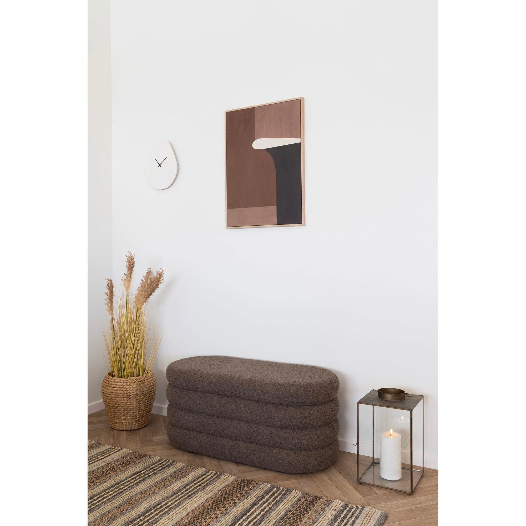 Banquette rembourrée en tissu marron pour le produit Horloge murale organique en ciment blanc cassé 28x33 cm