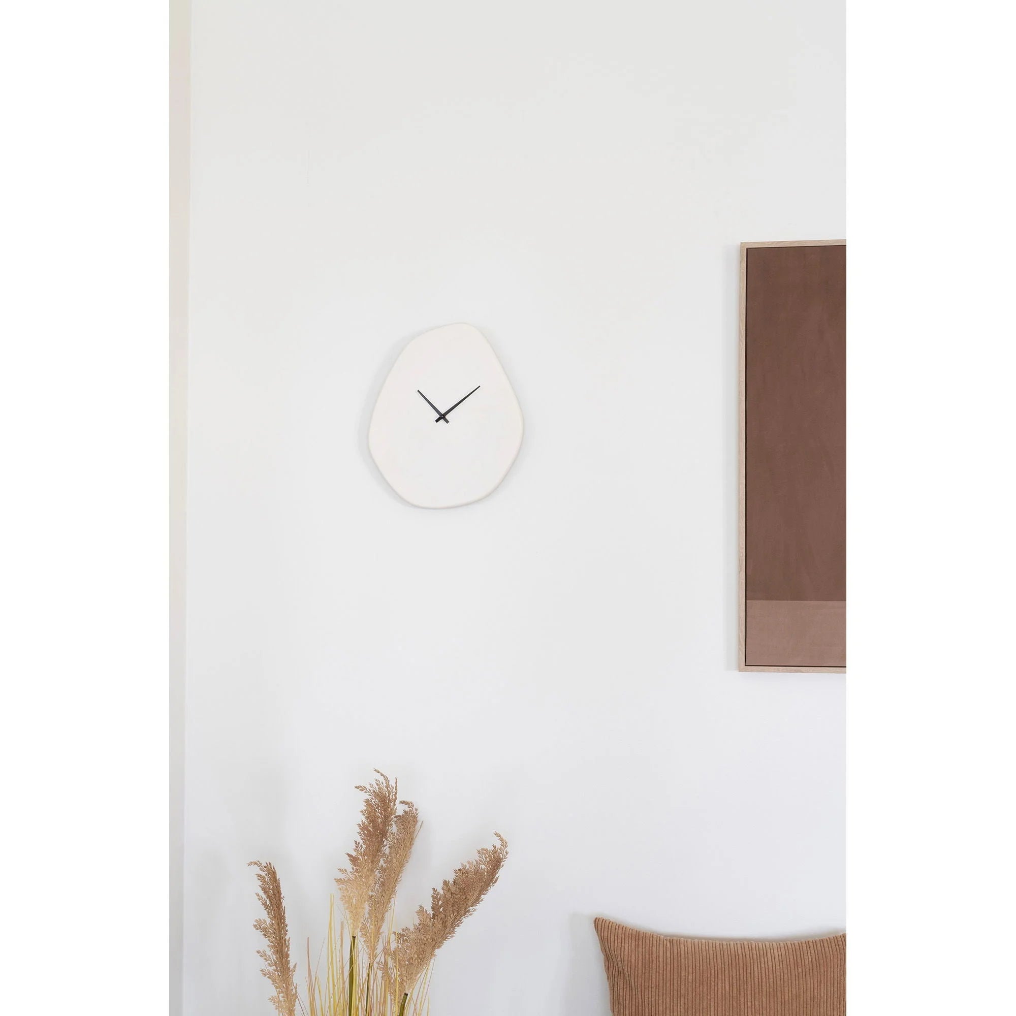 Horloge murale organique en ciment blanc cassé 28x33 cm with une forme irrégulière