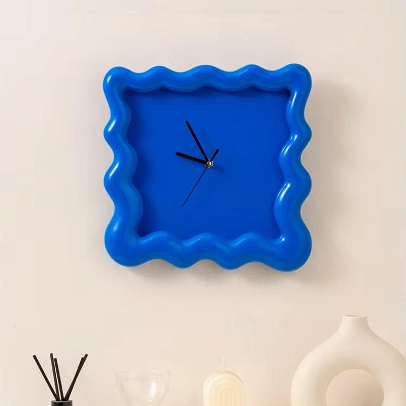 Horloge ondulée bleue accrochée au mur, design moderne.