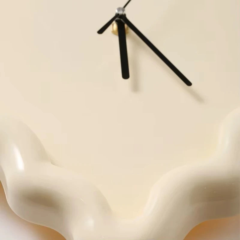 Gros plan sur le cadran et les aiguilles d’une horloge ondulée beige.