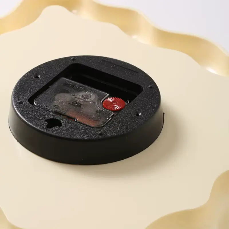 Vue arrière du mécanisme de l’horloge ondulée avec emplacement pour pile.