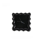 Horloge ondulée noire au design moderne et élégant.