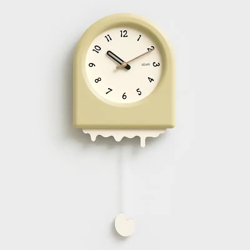 Horloge à pendule moderne taupe avec un effet fonte et un pendule décoratif en forme de goutte, sur fond blanc.