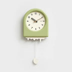 Horloge à pendule moderne verte avec un effet fonte et un pendule décoratif en forme de goutte suspendue.