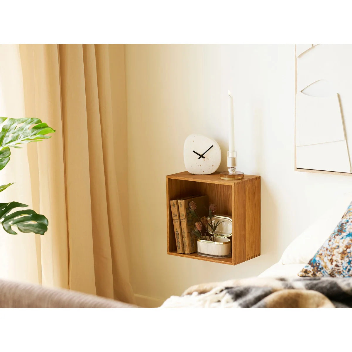 Horloge de table minimaliste en ciment blanc aspect pierre galet sur étagère bois clair