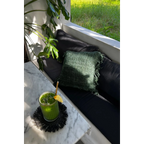 Verre vert vif avec glace, citron, paille dorée sur un dessous de verre à franges