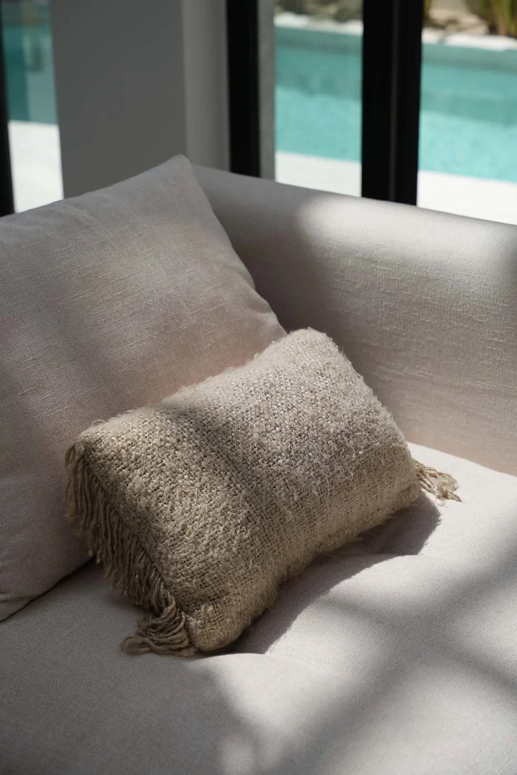 Housse de coussin beige texturée en coton avec franges, 30x50 cm sur canapé clair