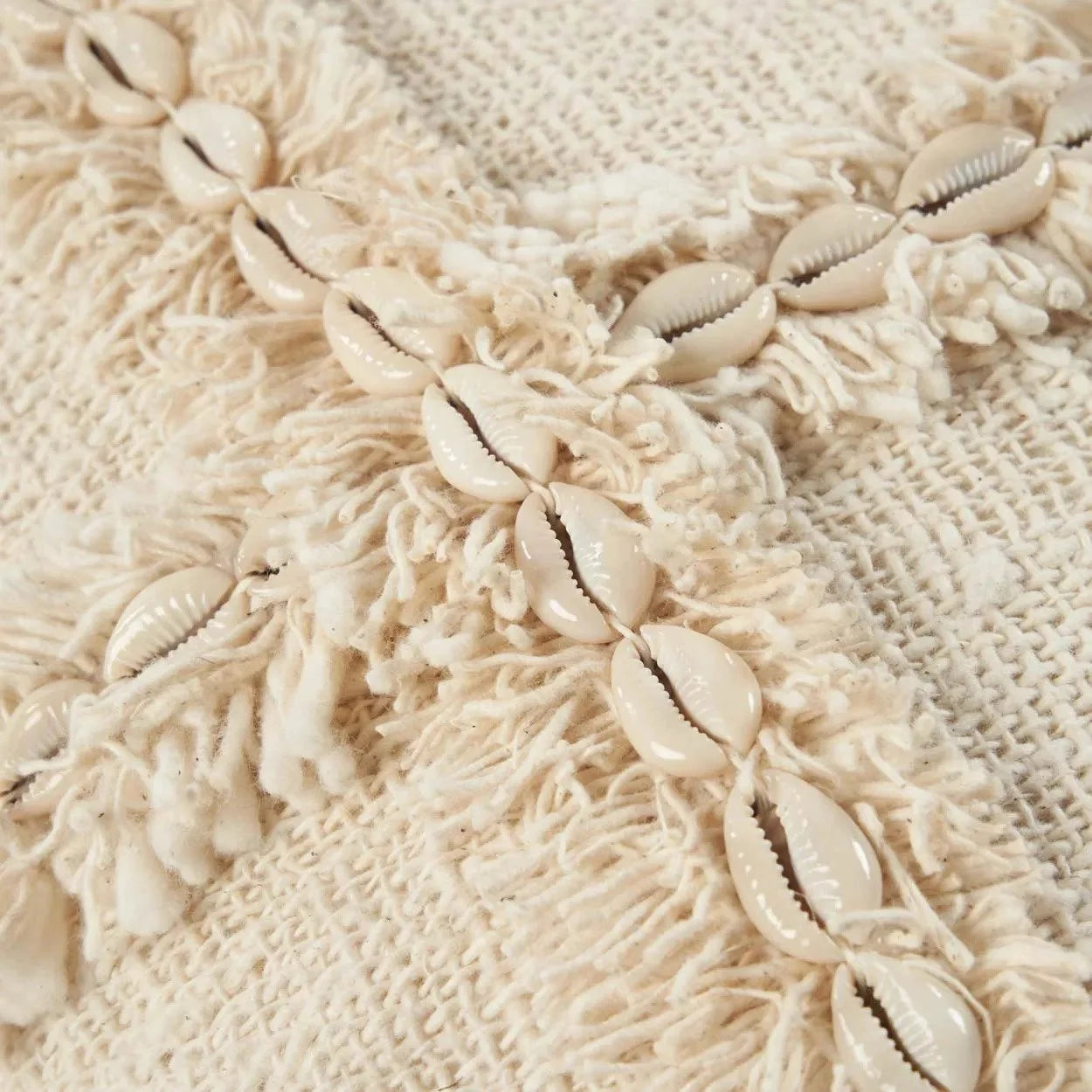 Housse de coussin carrée beige avec textile texturé, franges et coquillages Cowrie