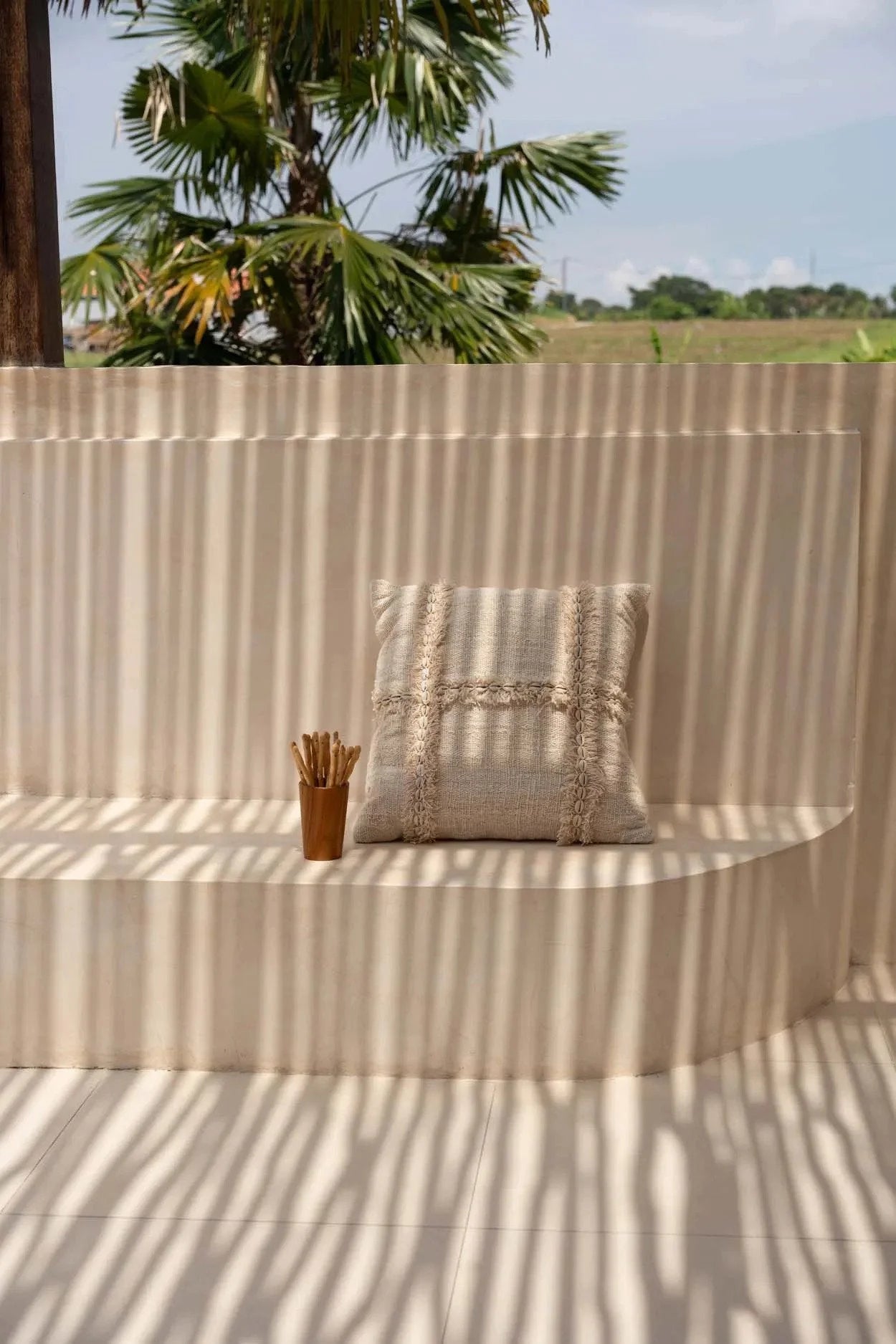 Housse de coussin carrée beige en tissu texturé avec franges et coquillages