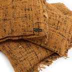 Coussin carré en coton tissé marron avec motifs noirs, franges et texture rugueuse