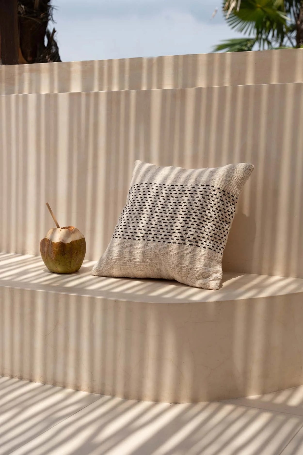 Housse de coussin carrée en coton tissé rayé noir avec un coussin beige et couture noire