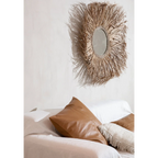 Miroir rond avec cadre en feuilles de palmier séchées naturel dans la pièce