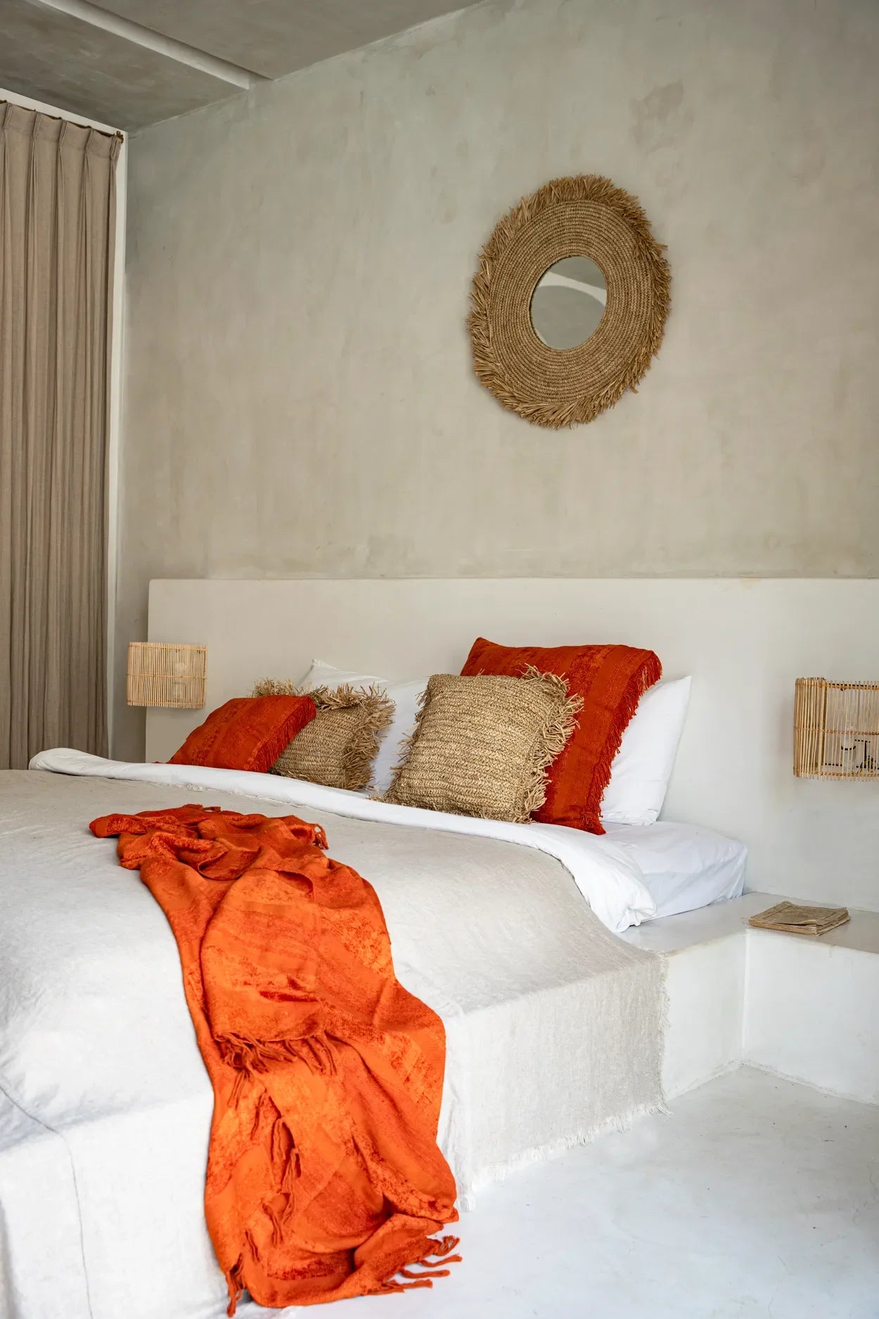 Housse de coussin carrée en velours rouille avec franges sur un lit confortable