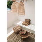 Housse de coussin coton beige noir 40x40 cm sur un coin lounge extérieur naturel