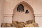 Housse de coussin coton beige noir 40x40 cm dans un coin de détente bohème avec lampes suspendues