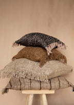 Oreillers décoratifs en frange empilés dans la housse de coussin en coton beige noir 60x60 cm