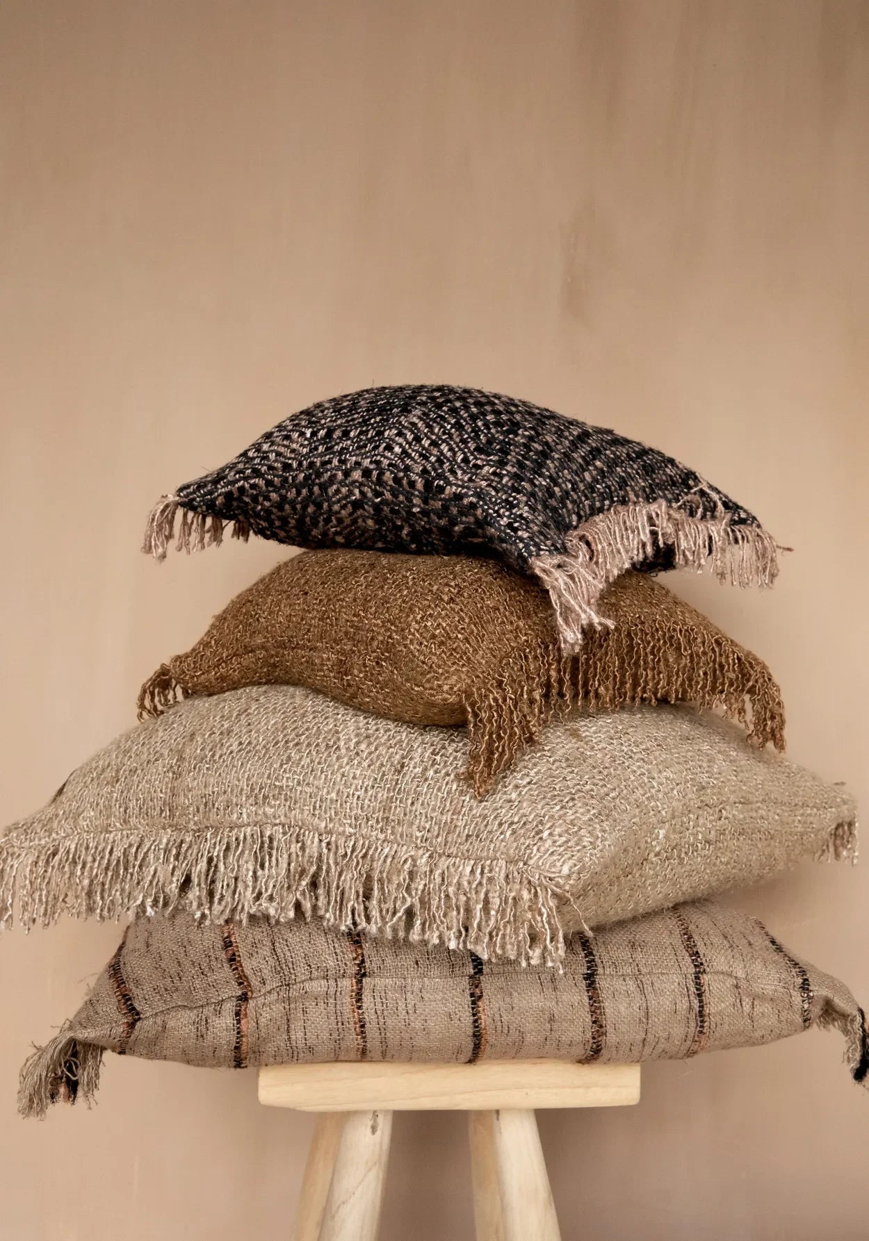 Oreillers décoratifs en frange empilés dans la housse de coussin en coton beige noir 60x60 cm