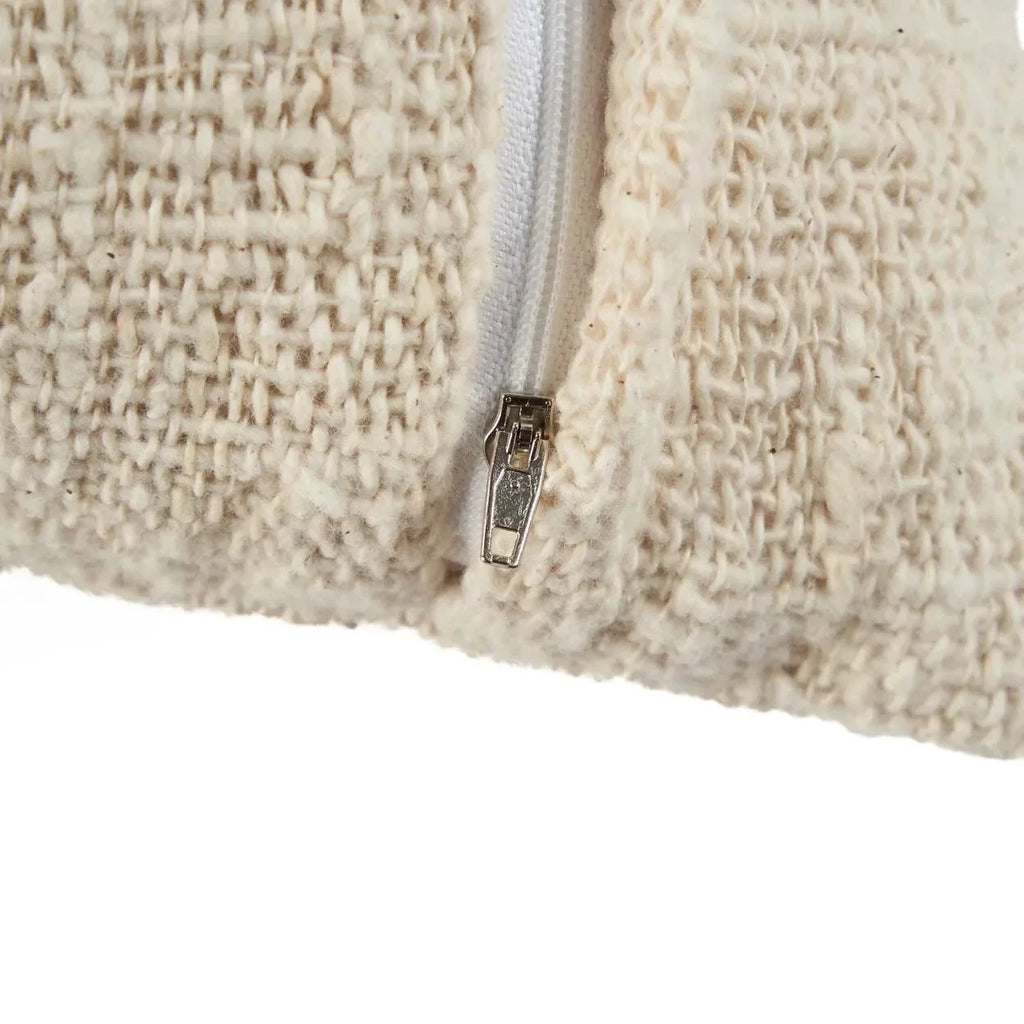 Zoom sur la fermeture éclair d’un coussin en coton blanc naturel avec motif palmier