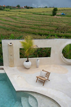 Housse de coussin coton blanc naturel motif palmier stylisé sur un patio avec piscine et terrasses agricoles