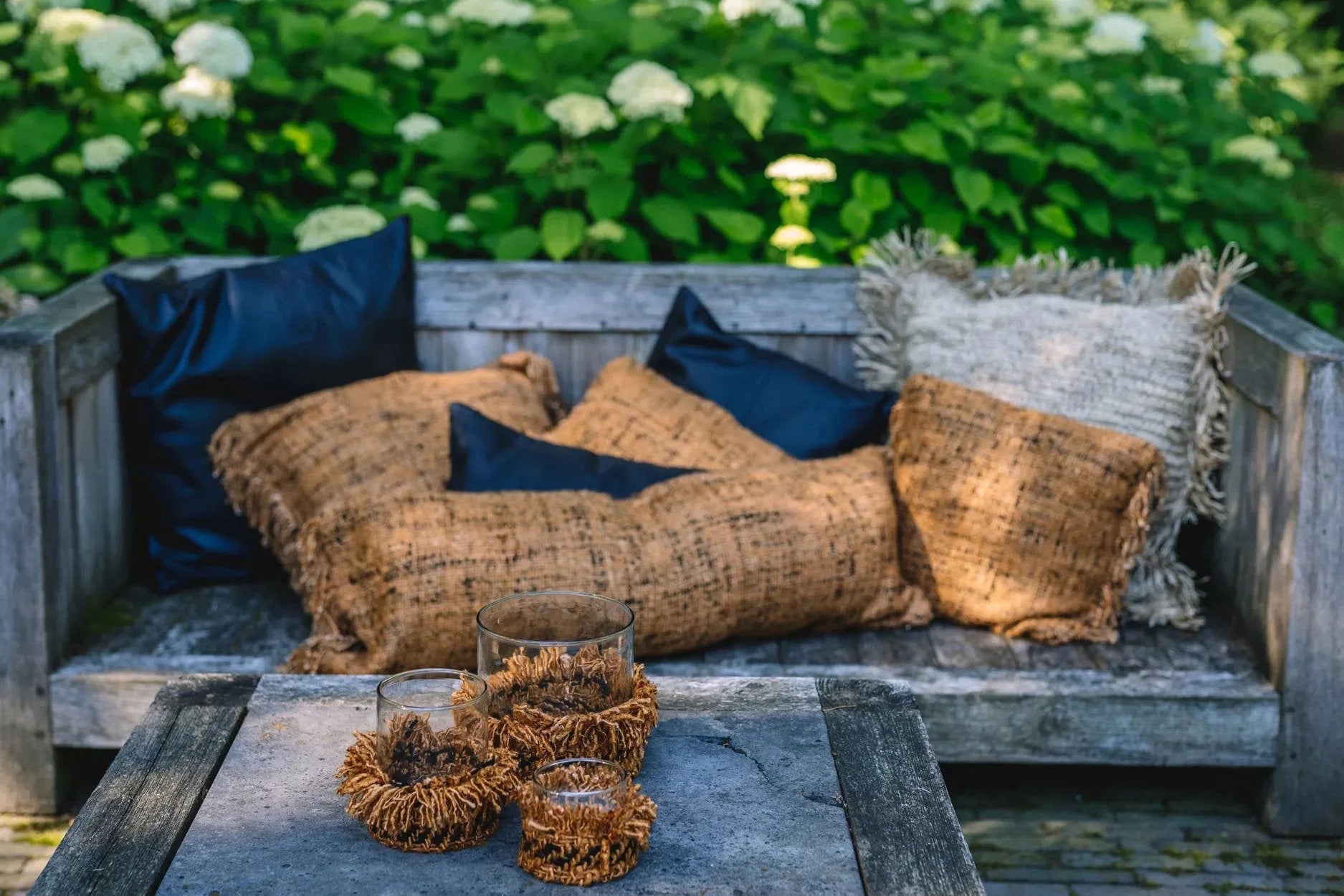 Housse de coussin en coton cannelle noir 35x100 cm sur un banc en bois avec coussins et bougies