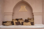 Coin déjeuner cocooning avec coussins en coton noir cuivre et luminaire en osier