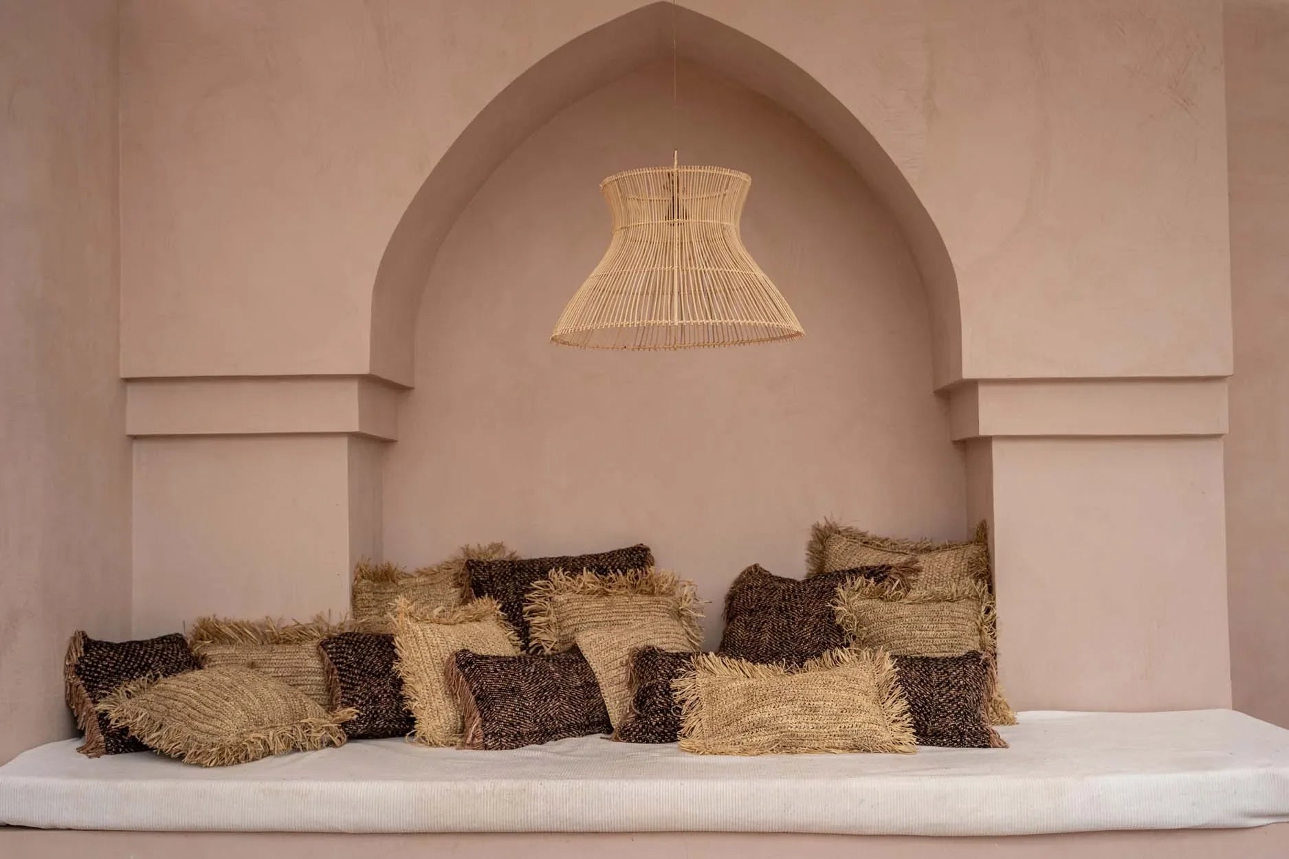 Coin déjeuner cocooning avec coussins en coton noir cuivre et luminaire en osier